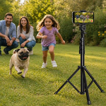 Family with a Pug in a park, using a smartphone on a tripod to record a video.